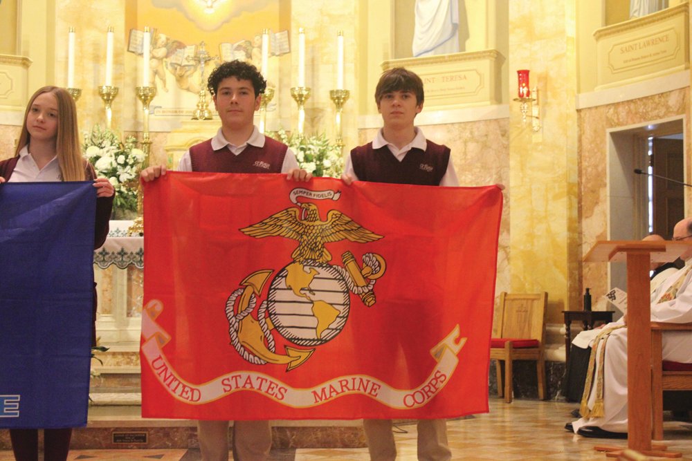 PATRIOTIC PRAYERS: Eighth grade students processed into the church with the flags of the five branches of the military. St. Rocco School held its Veterans Day Prayer Service Wednesday, Nov. 9 at St. Rocco Church, 931 Atwood Ave., Johnston. Students from St. Rocco School read poems that they wrote, carried photos of loved ones, sang patriotic songs and prayed for all veterans.  Also, the school held a “Dress Down Day” for "Operation Christmas Stocking" where students dressed in red, white and blue, along with donating a dollar for the cause. Proceeds will go toward filling stockings for soldiers in the 43rd MP Brigade.